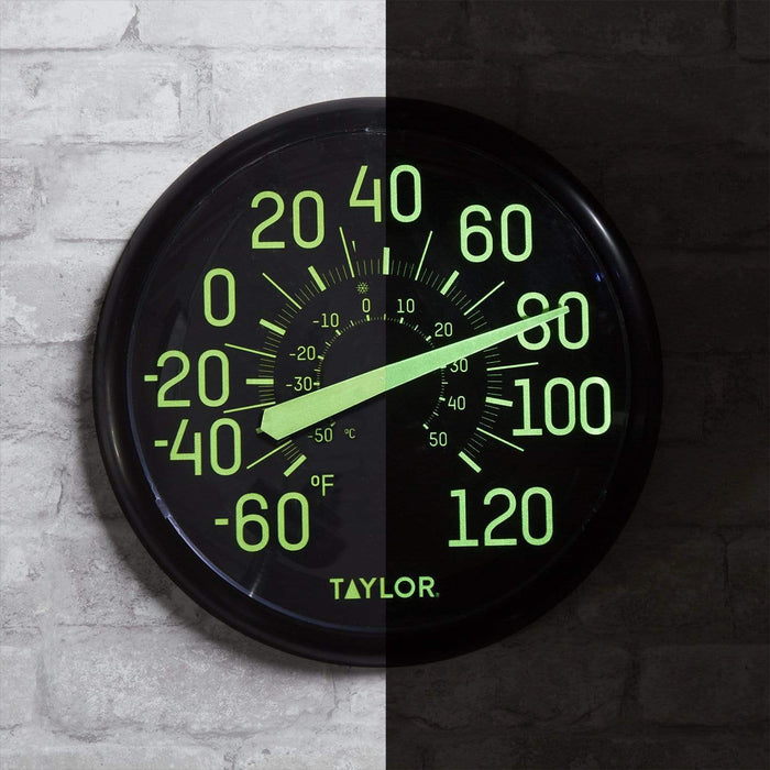 Split view of a Taylor glow in the dark outdoor thermometer on a brick wall with neon green digits.