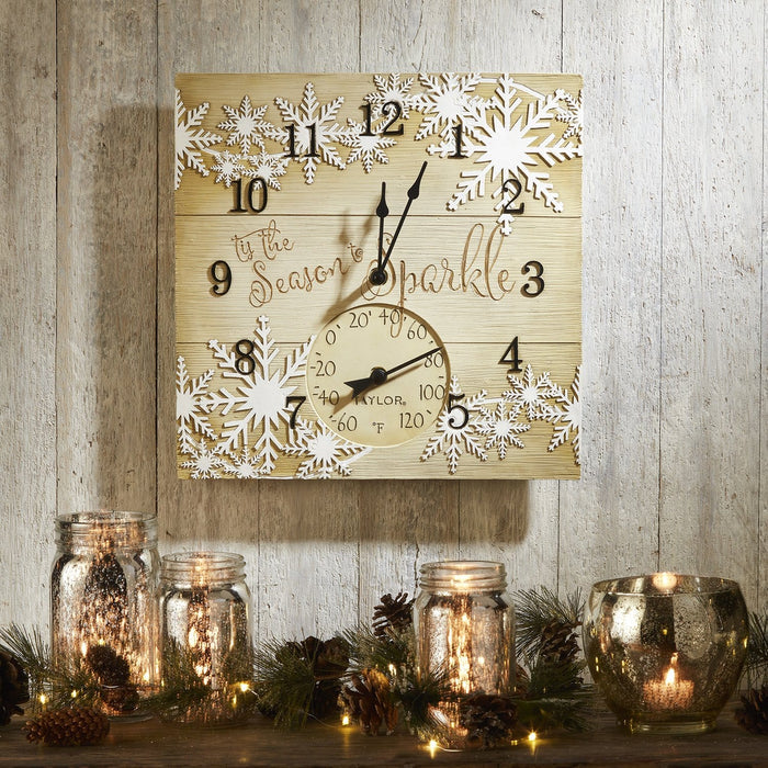 Lifestyle shot of the clock mounted on a rustic wood wall with candles and pinecones for festive décor.