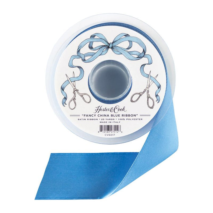 A spool of blue satin ribbon by Hester & Cook on a white background.
