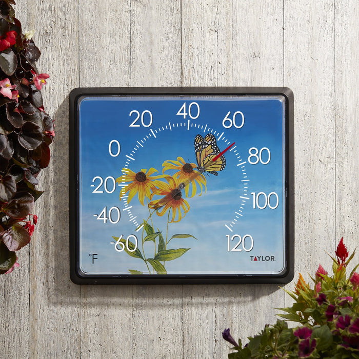 12x14 Dial Thermometer Butterfly with a blue sky background mounted on weathered wood beside pink flowers
