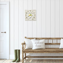 Lemonade Clock with Thermometer mounted on a white paneled wall above a wooden bench in a bright room.