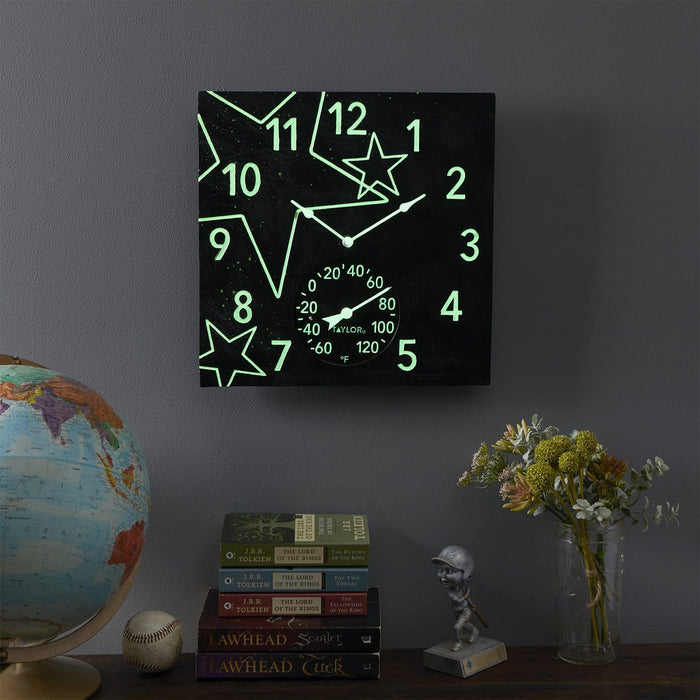 Square black clock with glowing green stars and numerals and a thermometer dial at the bottom