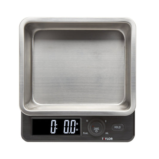 Close up of a Taylor 22 lb kitchen scale with a stainless steel storage container and lid.