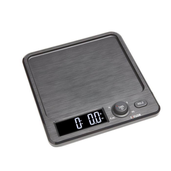 Corner view of a 22 lb kitchen scale with brushed dark finish and a stainless steel storage container lid