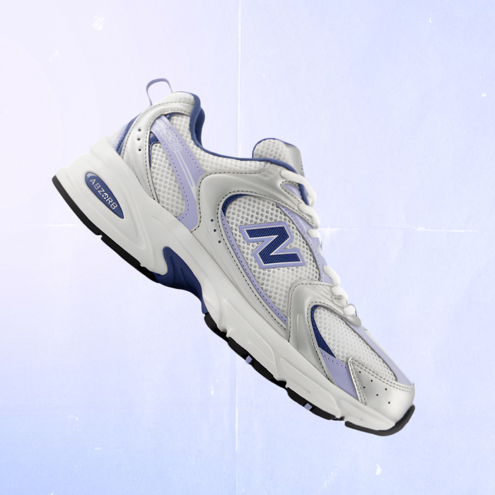 White and blue sneaker with New Balance logo on a light blue background