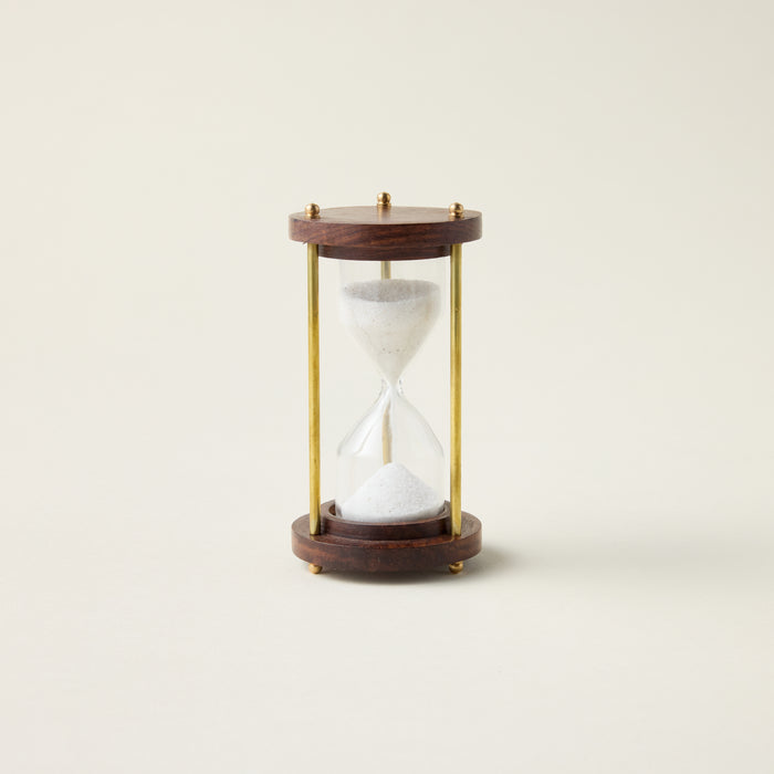 Antique hourglass with a solid wood and brass frame, styled as a timeless and sophisticated decor accent.