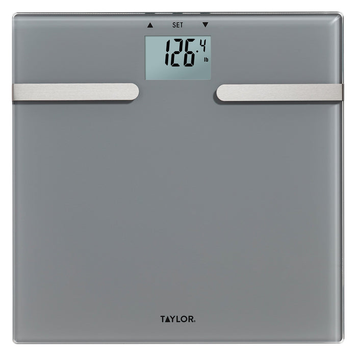 Charcoal gray body composition scale with digital readout showing 126.4 lb and two silver metal bars across front
