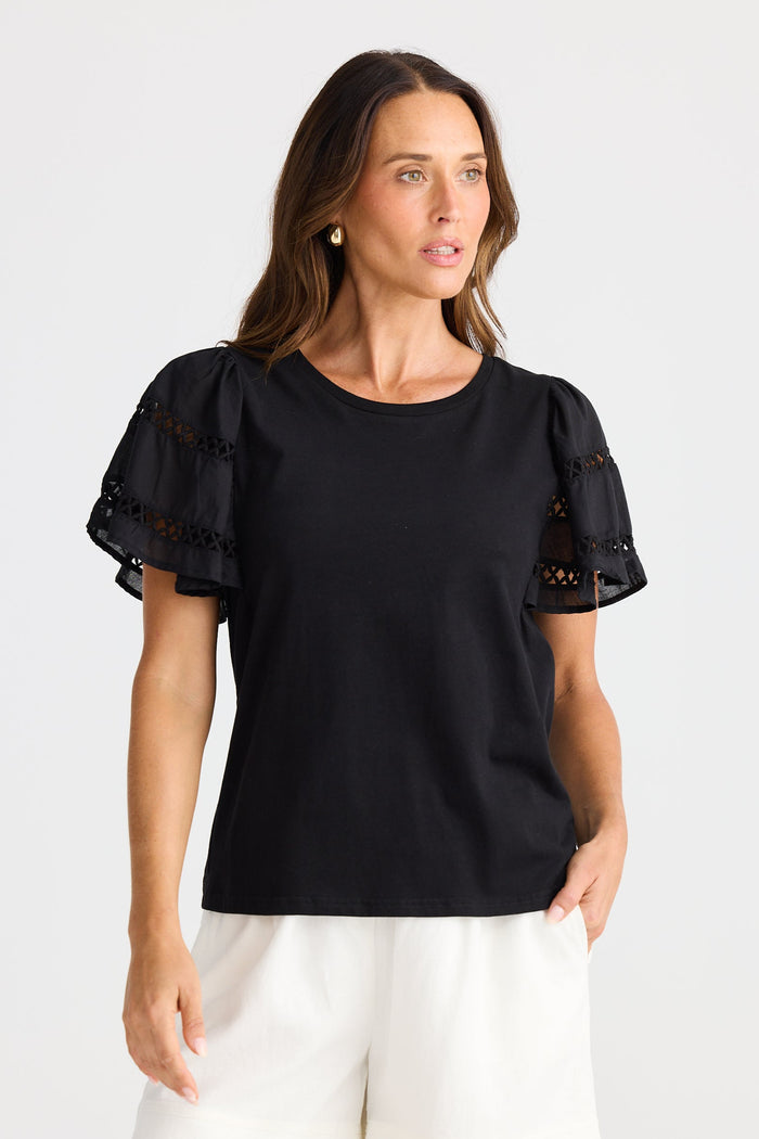 Woman wearing a black blouse with lace sleeves on a white background