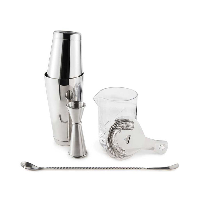 Set of cocktail-making tools including a shaker, jigger, measuring cup, and strainer on a white background.