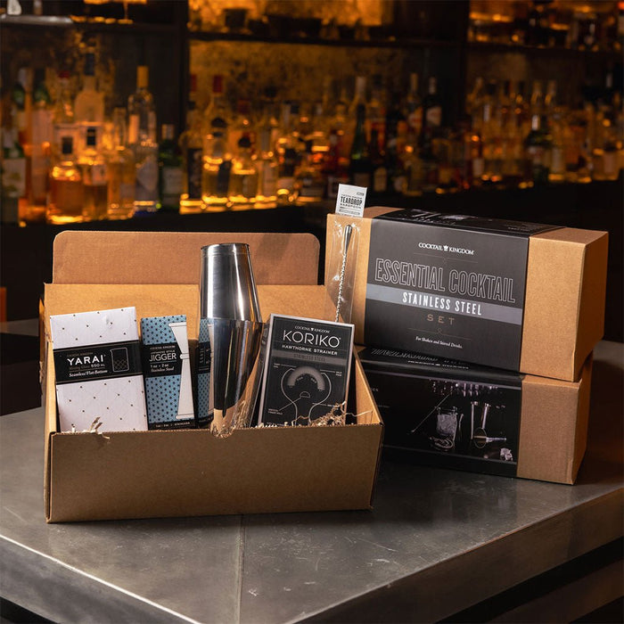 Cocktail-making set with tools and packaging on a bar counter