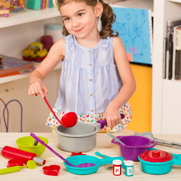 A toy cooking set with a huge variety of different tools in a green bin.