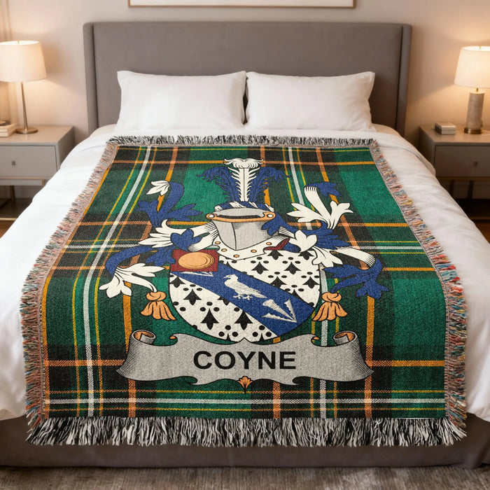 Coyne family crest woven blanket spread on a bed.