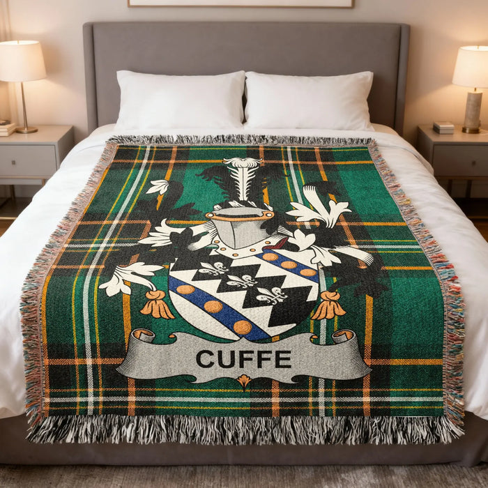 Cuffe family crest woven blanket spread on a bed.