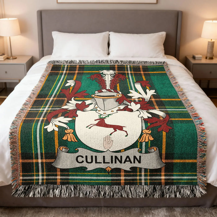 Cullinan family crest woven blanket folded over a bed.