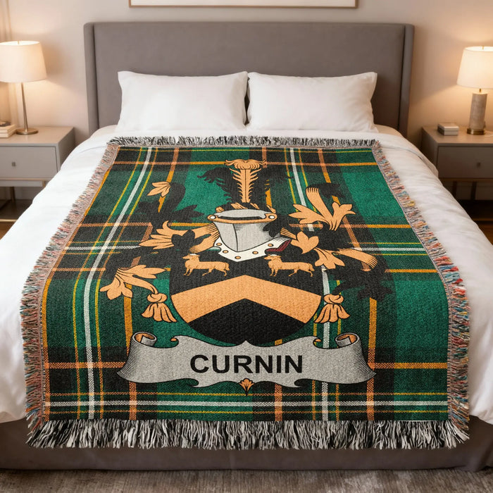 Curnin family crest woven blanket folded at the end of a bed.