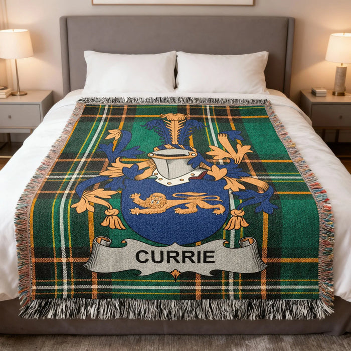 Currie family crest woven blanket laid across a bed.