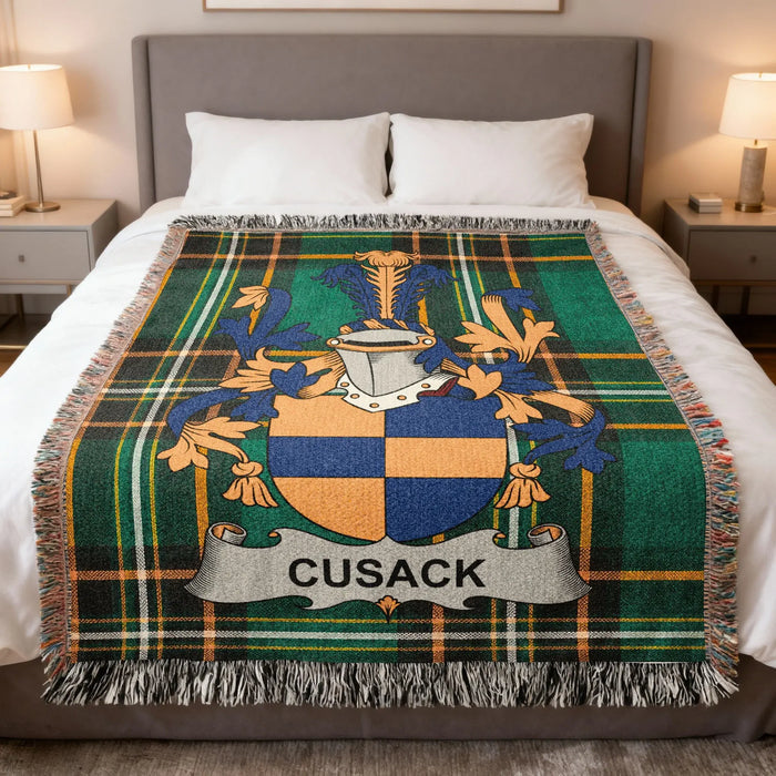 Cusack family crest woven blanket laid across a bed.
