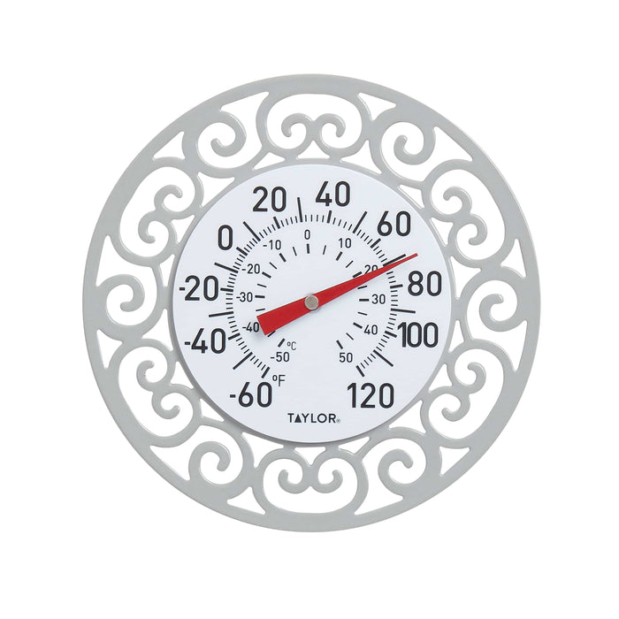 Decorative round metal frame with ornate scrollwork encasing a Taylor thermometer dial