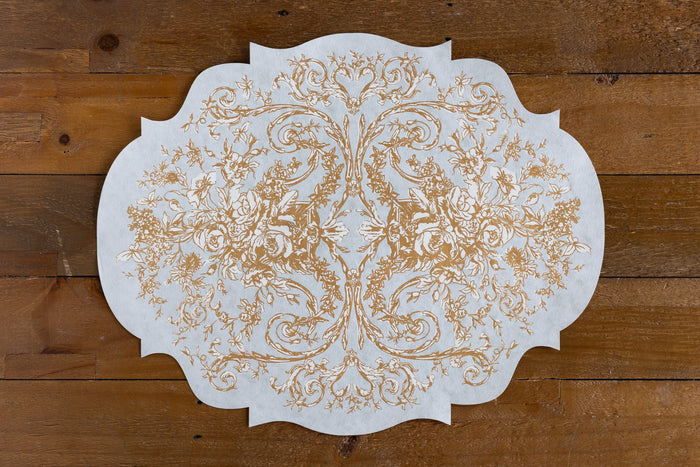 Die-Cut Gilded Scroll Frame Placemat on a wood background.