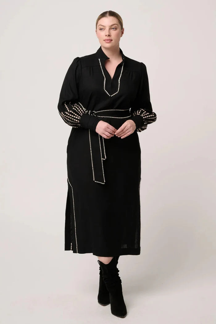 Woman wearing a black dress with decorative elements on a white background