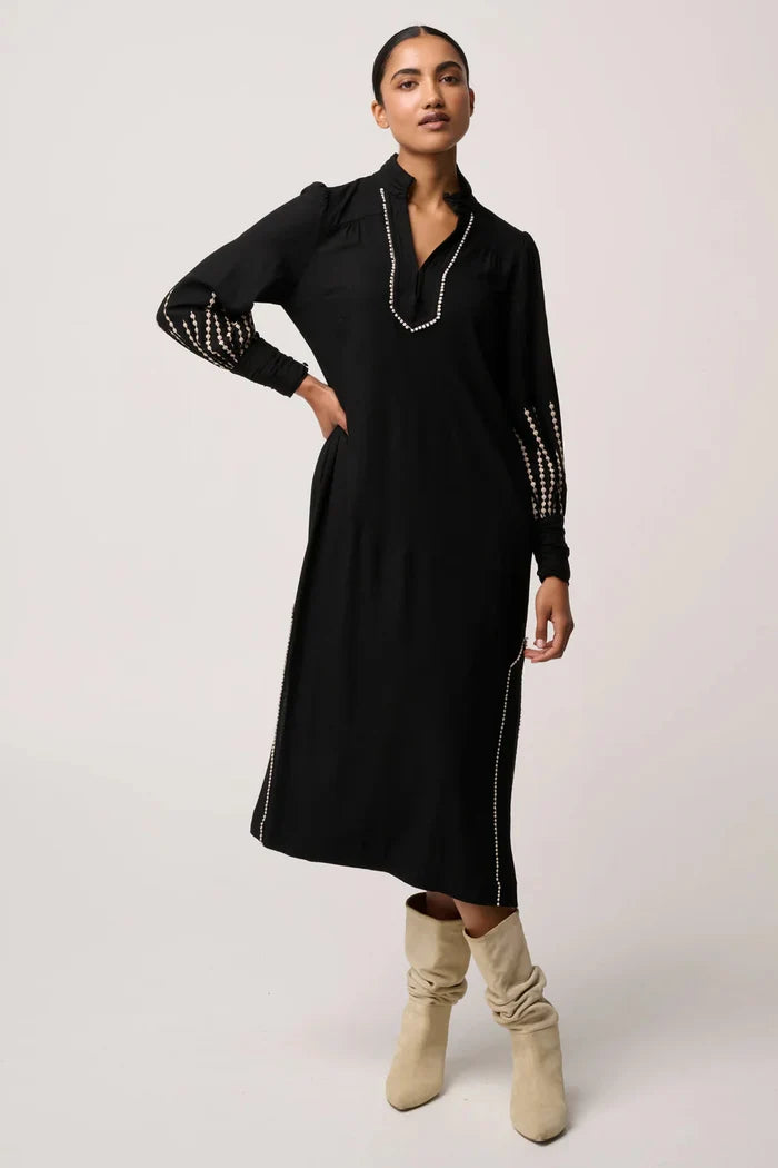 Woman wearing a black dress with white trim on a white background