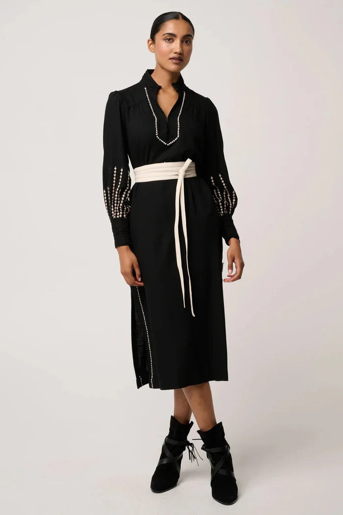 Woman wearing a black dress with white trim on a white background