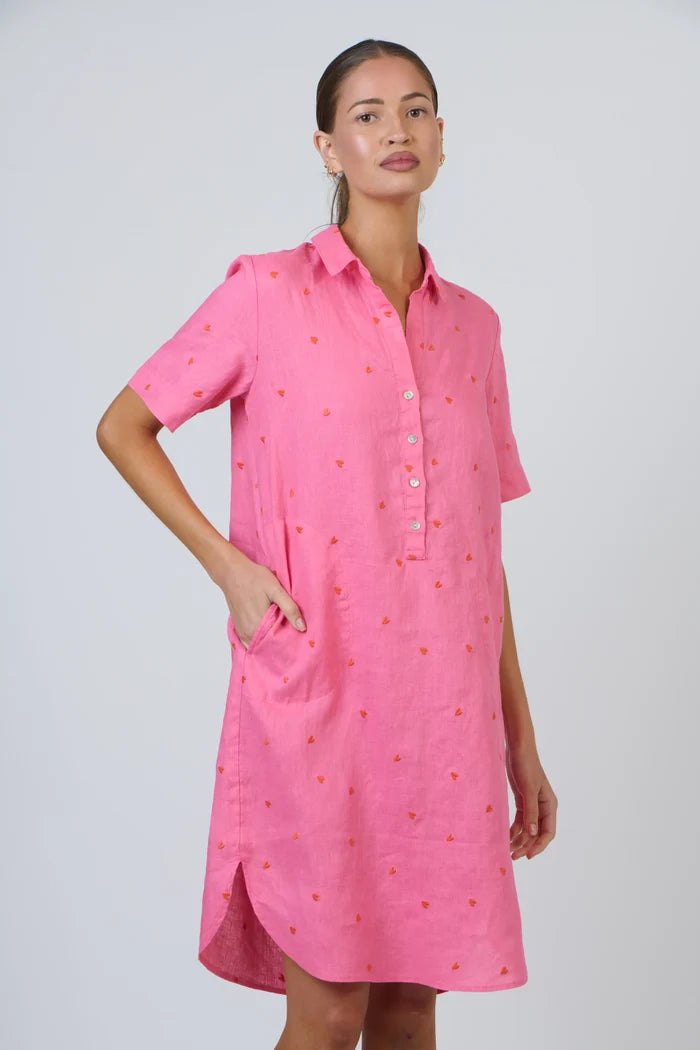 Woman wearing a pink dress with a subtle pattern on a white background