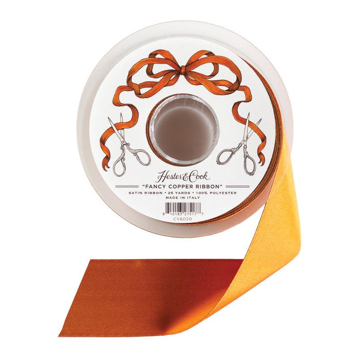 A spool of coppery orange satin ribbon by Hester & Cook on a white background.