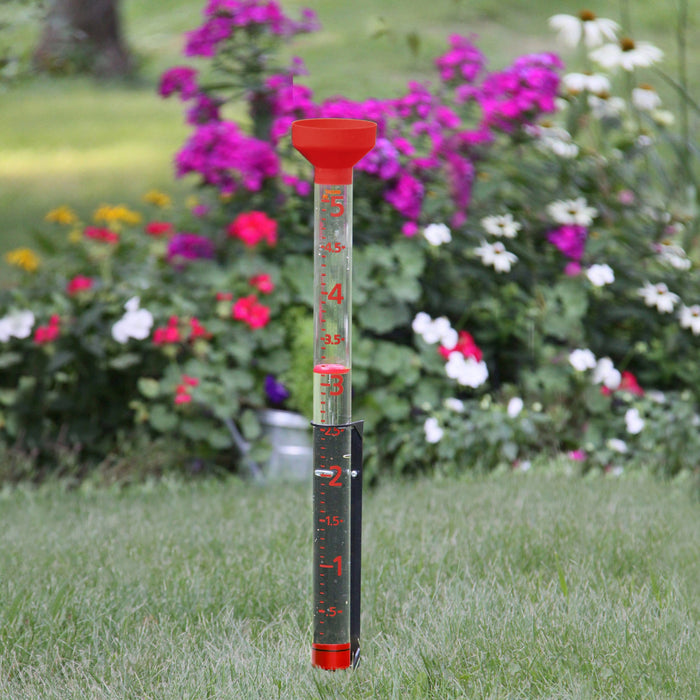 Jumbo Jr Easy-to-View Rain Gauge in a garden with colorful flowers in the background