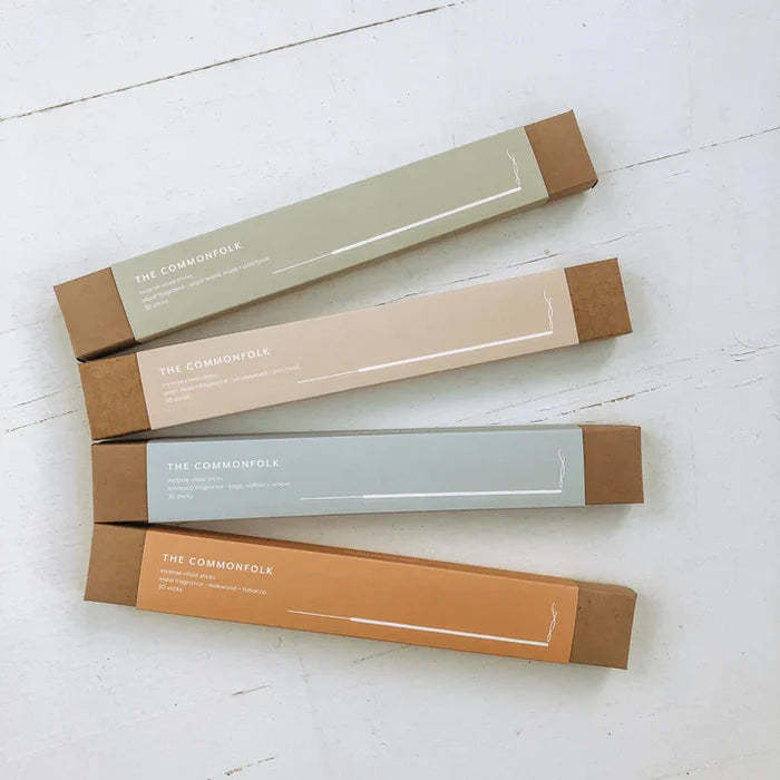 Four cardboard boxes from 'The Commonfolk' on a light wooden surface
