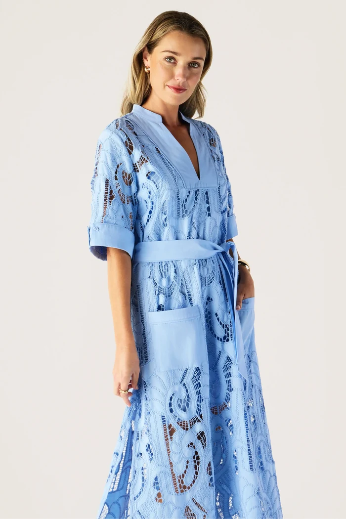 Woman wearing a blue lace robe against a plain background