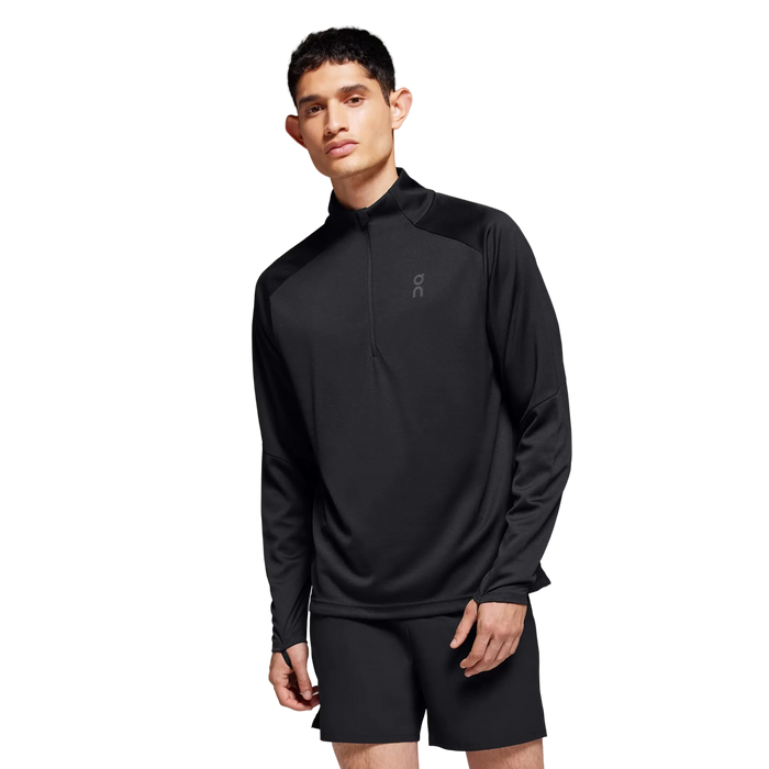 Man wearing a black athletic outfit on a gray background