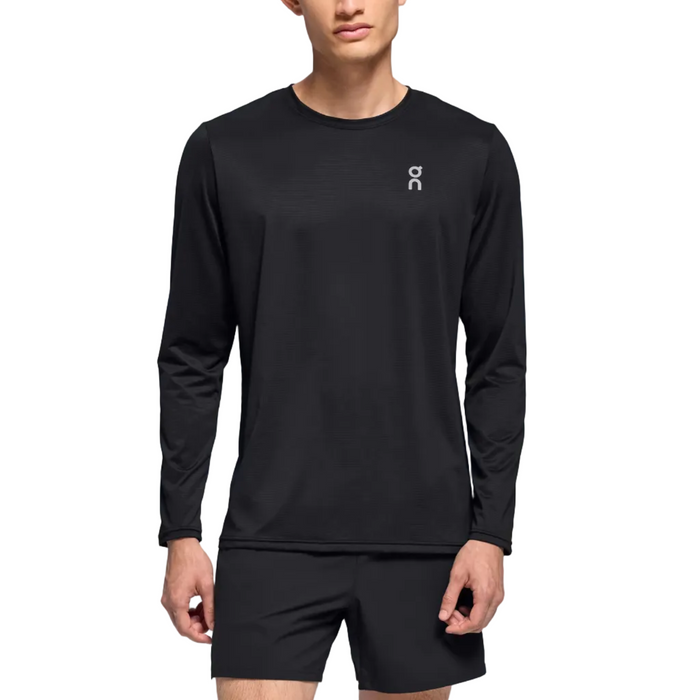 Man wearing a black long-sleeve athletic shirt and shorts on a gradient background