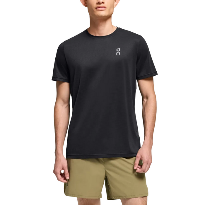 Man wearing a black t-shirt and green shorts on a gradient background