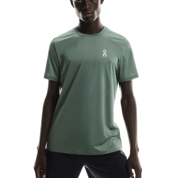 Person wearing a light green t-shirt with a logo on a white background