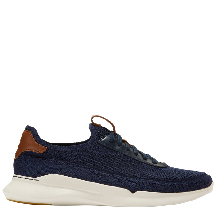 A navy blue and brown Cole Haan men's sneaker with a knit upper and a lace-up closure.