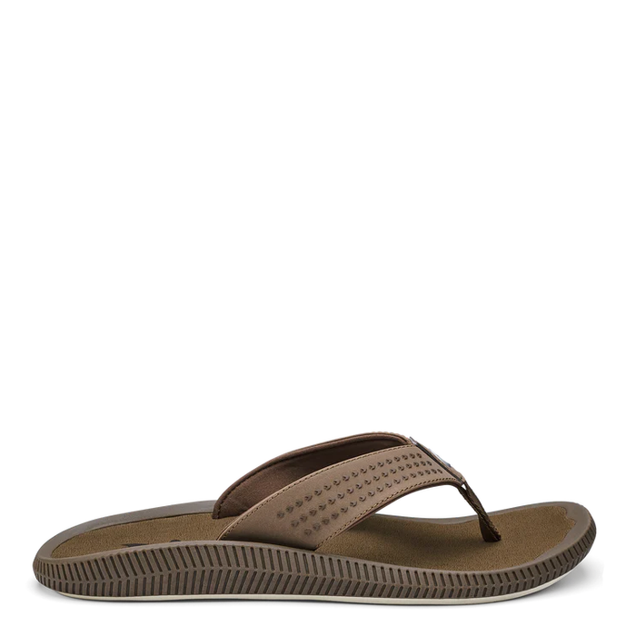 A brown OluKai men's sandal with a lightweight sneaker-like build, water-resistant materials, and a Kalo plant-inspired design.