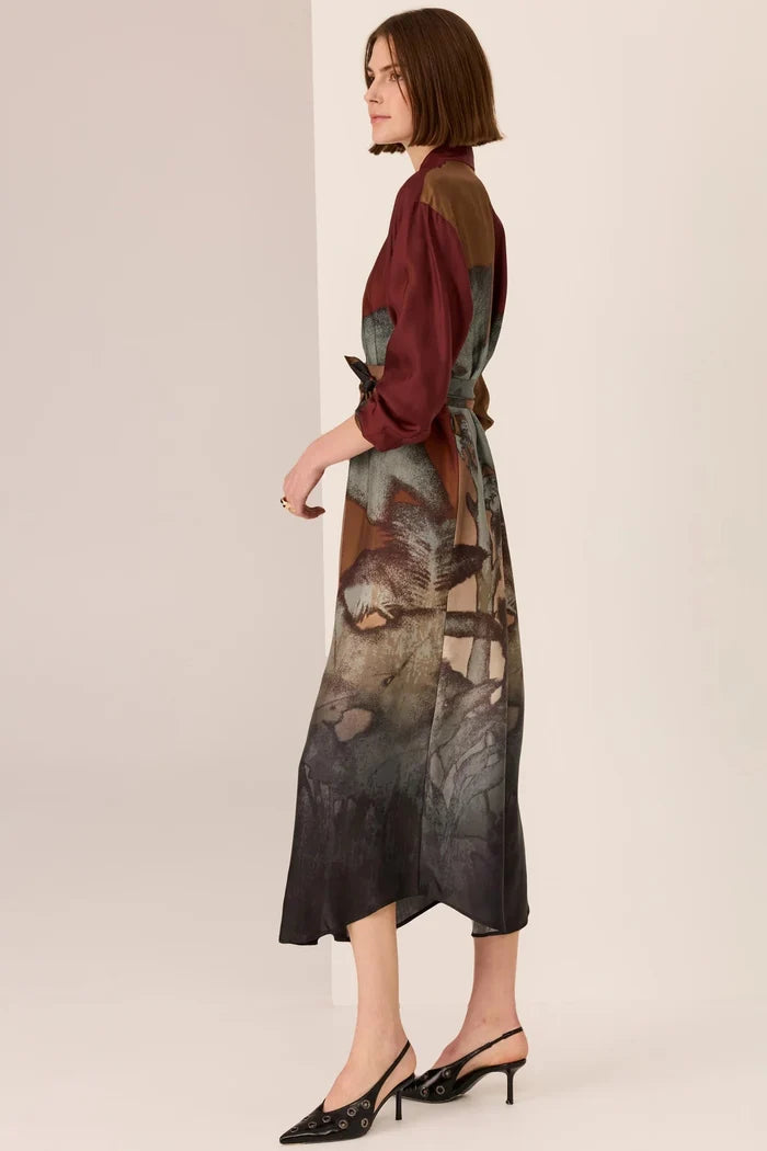 Woman wearing a patterned dress with a plain background