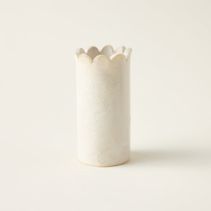 Handcrafted petite ceramic vase with a unique hand-cut scallop top and a minimalist cylindrical shape.