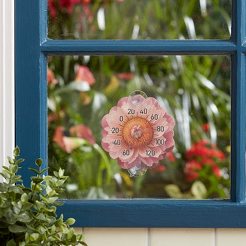 Pink peony silicone suction cup thermometer attached to blue window glass