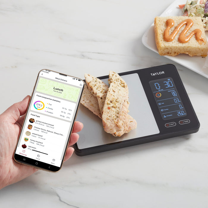 Phone screen displays meal details in the Precision Hub app beside the scale and slices of bread on the counter