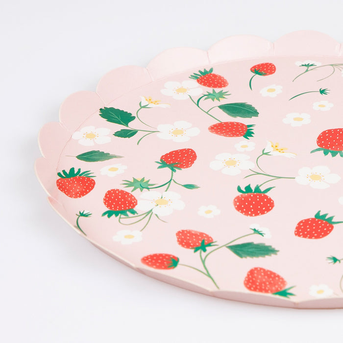 A close-up of a paper plate with strawberry and flower pattern laid flat on a white background.