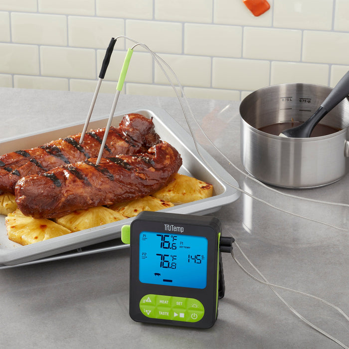 TruTemp dual probe programmable thermometer with two probes inserted into glazed ribs on a metal tray.