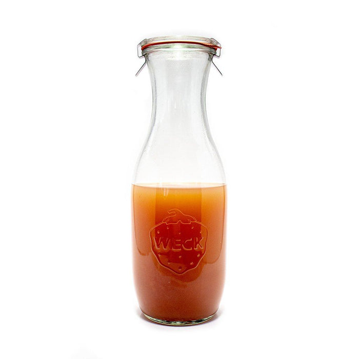 Glass Weck Juice Jar carafe with glass lid and clamps with juice inside on white background