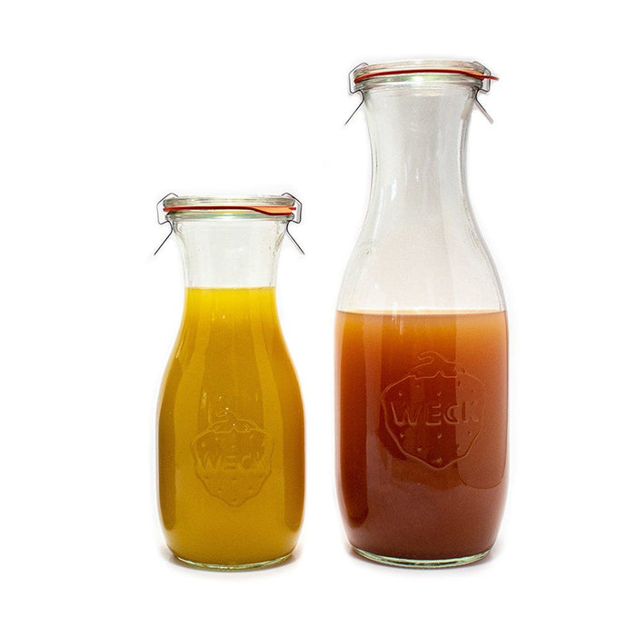 Two glass Weck juice jars with juice inside on white background