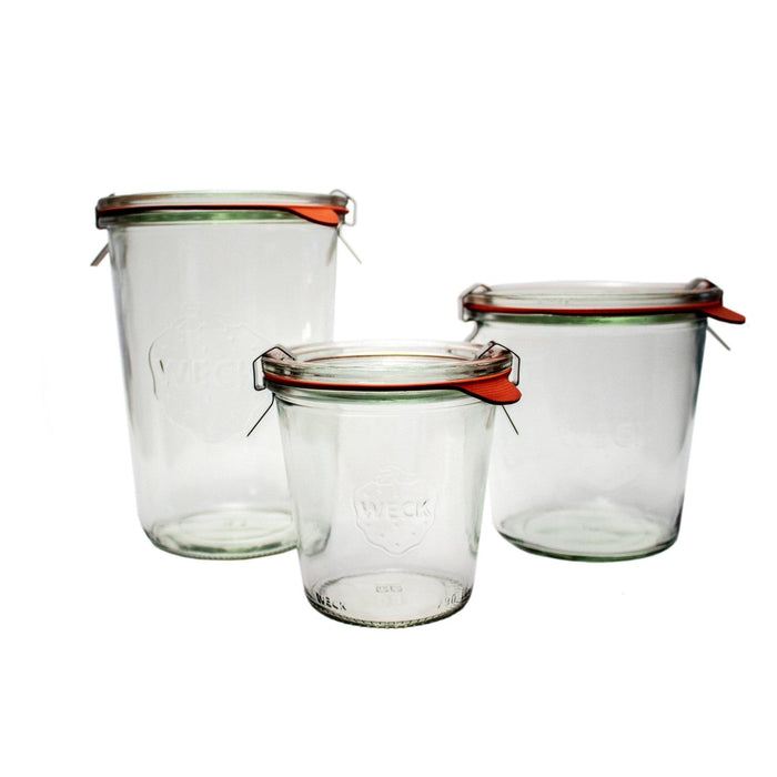 Set of three glass Weck Mold Jars with glass lids and clamps on white background