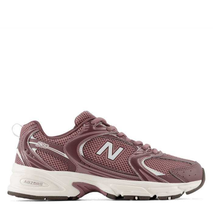 A New Balance sneaker in a dusty mauve-brown colorway, featuring a white midsole and a metallic silver 'N' logo on the side, shown against a plain white background.