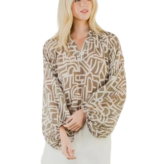 Woman wearing a patterned blouse over a plain dress on a white background