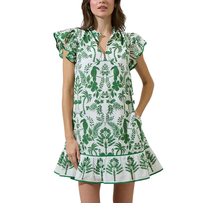 Woman wearing a green and white patterned dress against a plain background