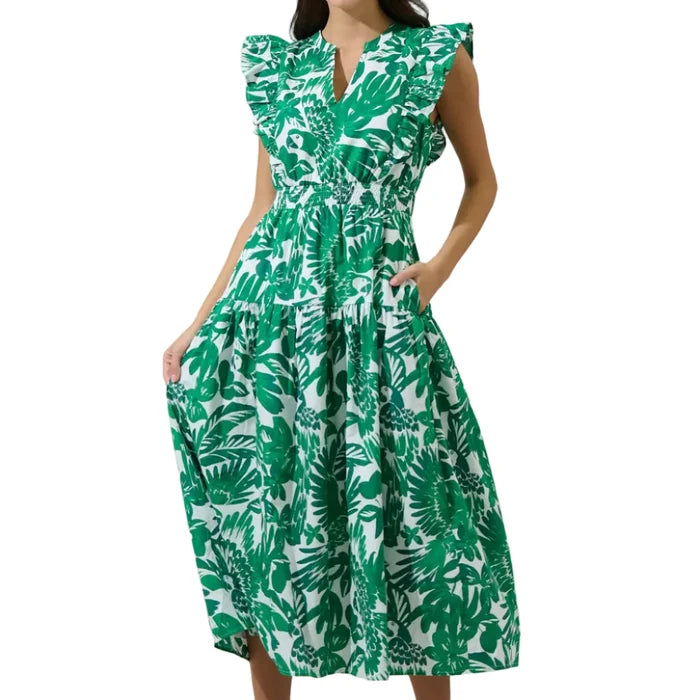 Woman wearing a green leaf-patterned dress against a plain background